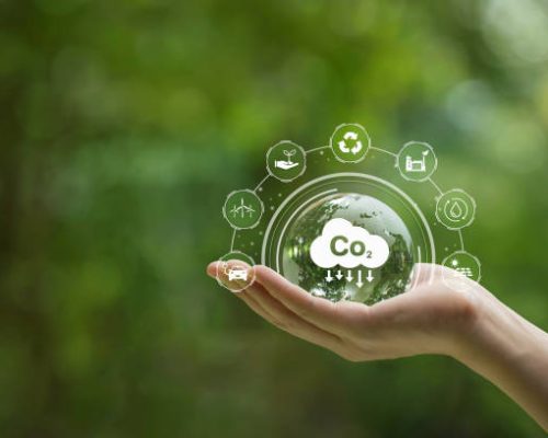 Reduce CO2 emission concept. Hand-holding crystal globe with a CO2 icon. Ideas for Sustainable development and green business based on renewable energy. Energy saving, Sustainable development.